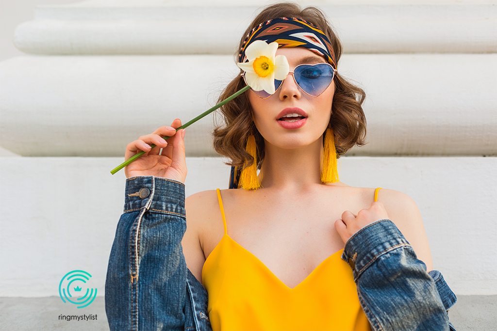A woman with a flower in hand A colorful woman wearing glasses, covering an eye with a daffodil