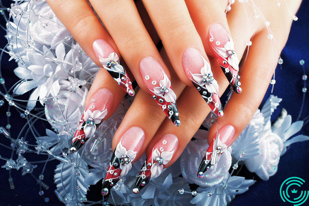 Floral manichiure on long nails Woman's hand with long, sharp nails, floral pattern, with shades of white, red and black