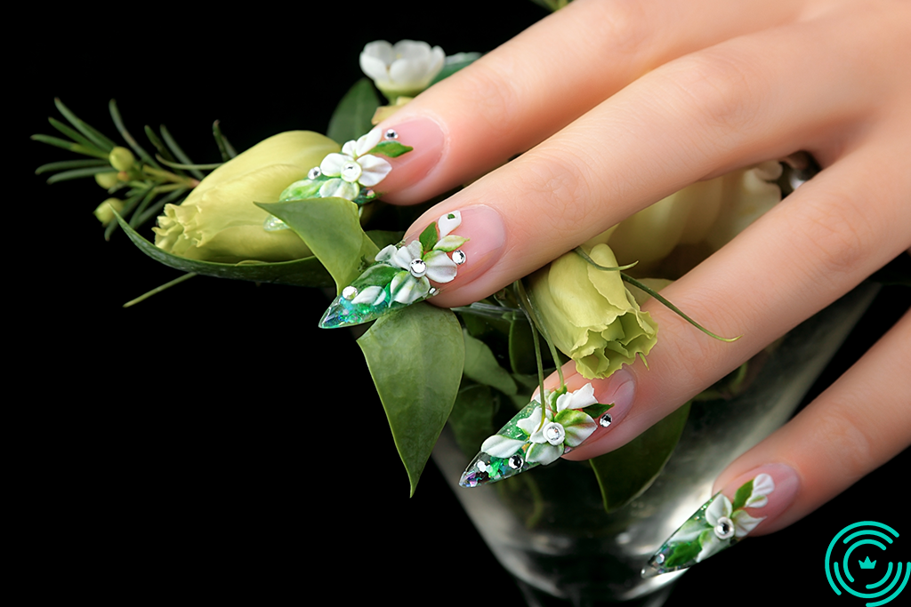 Woman's hand with long, sharp nails, with 3D floral pattern, predominantly green