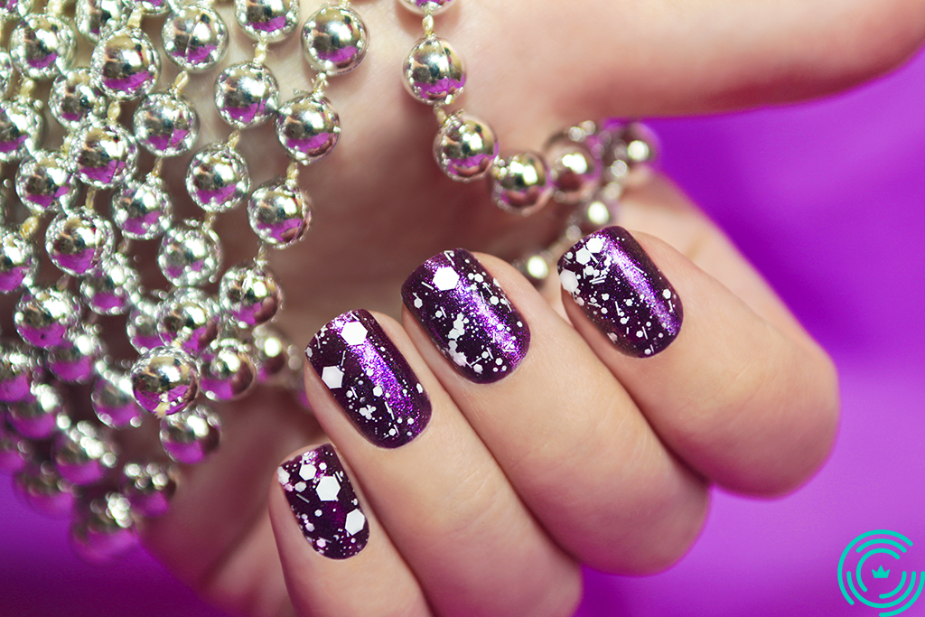  Woman's hand with glossy purple right manicure